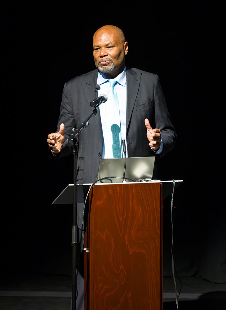 Dr. William A. Smith speaking on stage behind a podium