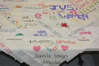 Bandanas with artwork and messages on them. Examples of messages include "Mujeres Unidas" and "Justice 4 Women". Examples of artwork are hearts ands hands shaking.