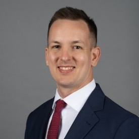 Headshot of a man wearing a suit.
