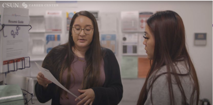A career center staff member speaks with a student in the center.