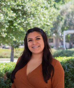 Portrait photo of a women smiling outside in the sun. 