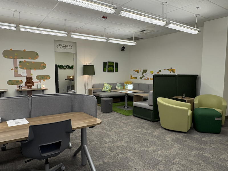 FacDev Commons room with desk, couch, and arm chairs.