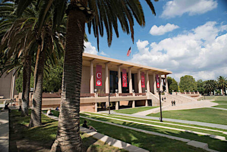 The exterior of the CSUN library with palm trees in the foreground