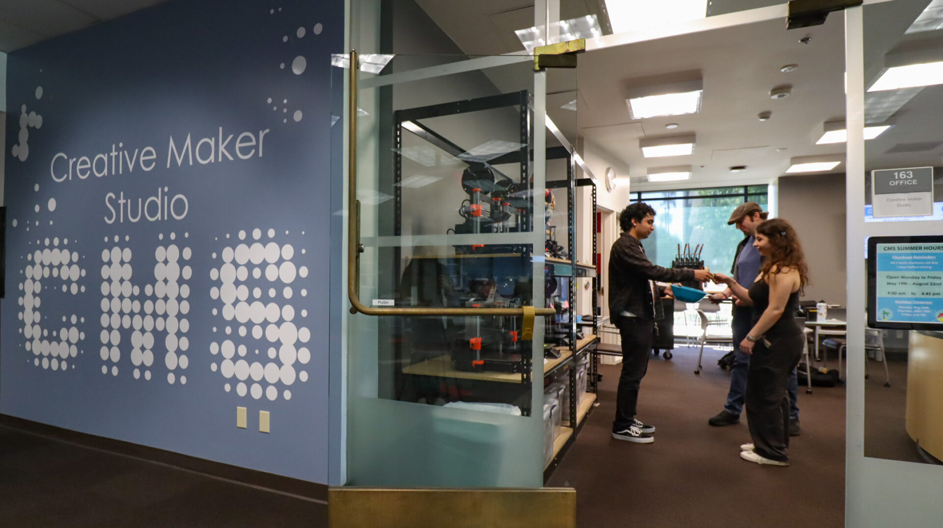 Three people inside the Creative Maker Studio.