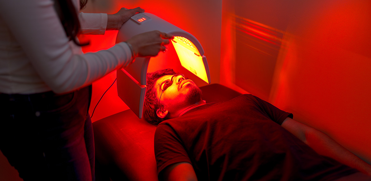 Student using face red light therapy