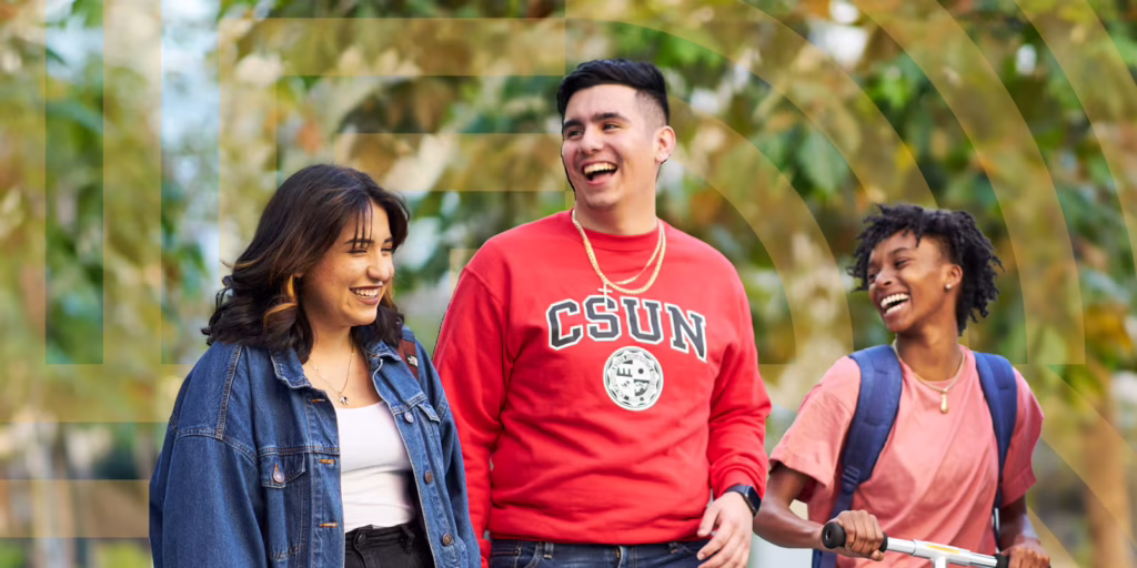 Three CSUN students talking as they walk across campus.